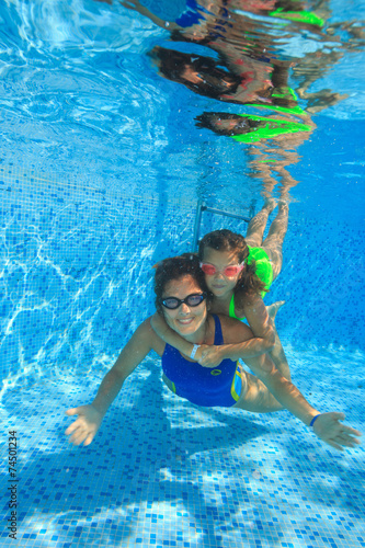 Mother and daughter dive in the swimming pool