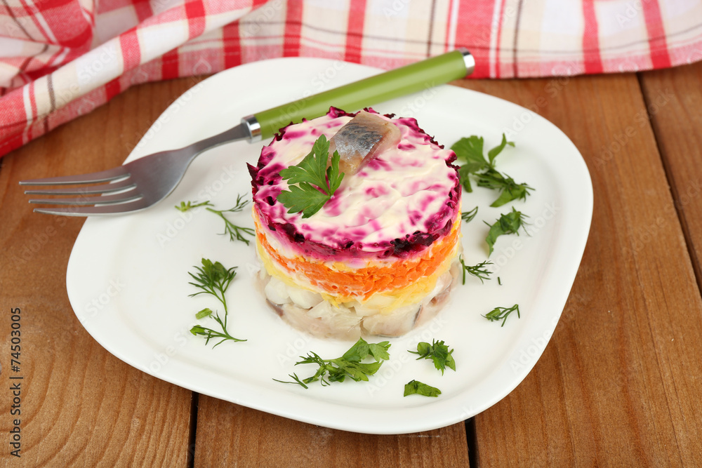 Russian herring salad on plate on wooden table background Russian herring salad on plate on wooden table background