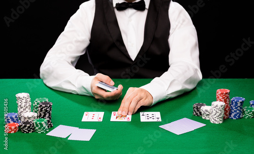 holdem dealer with playing cards and casino chips photo