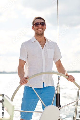 Konstfotografi young man in sunglasses steering wheel on yacht