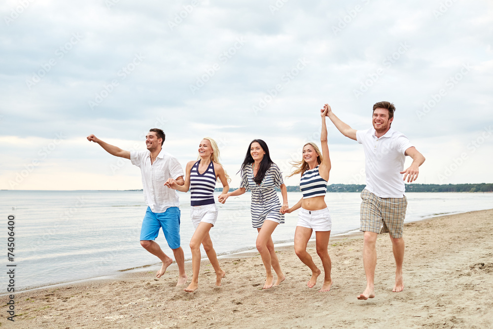 smiling friends in sunglasses running on beach smiling friends in sunglasses running on beach