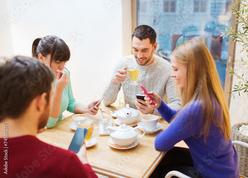 group of friends with smartphones meeting at cafe