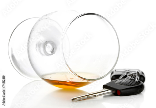 Glass of alcoholic drink and car key  isolated on white