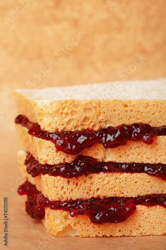 Tasty sandwich with jam, on brown background