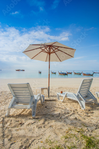 Beach chairs with white umbrella and beautiful sand beach