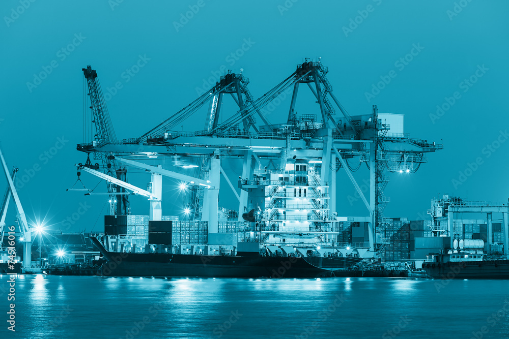 Gantry crane loading and unloading cargo container  from cargo ship at port to show global international logistics and transportation by cargo ship and cargo container, Logistic import export concept.