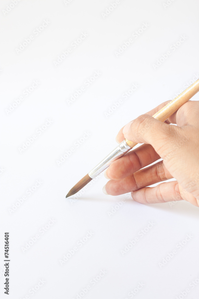 Hand with a brush. Over a grey empty paper Hand with a brush. Over a grey empty paper