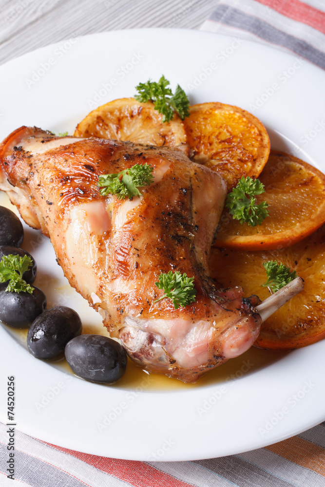roasted rabbit leg with oranges and olives. vertical