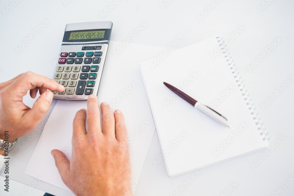 Hand of man using a calculator Hand of man using a calculator