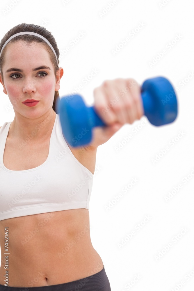 Fit brunette holding blue dumbbell Fit brunette holding blue dumbbell