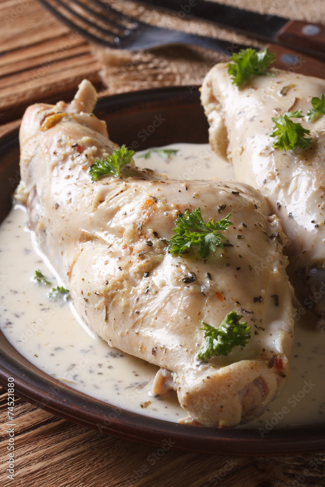 Rabbit meat stewed in sour cream close-up on a plate. vertical Rabbit meat stewed in sour cream close-up on a plate. vertical