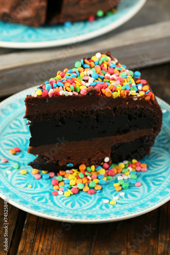 Chocolate cake with colorful sweet powder on table close-up