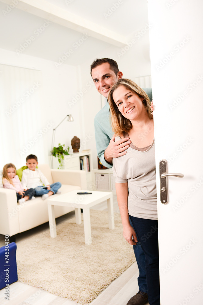 happy family with young kids welcoming a guests at home doorh happy family with young kids welcoming a guests at home doorh