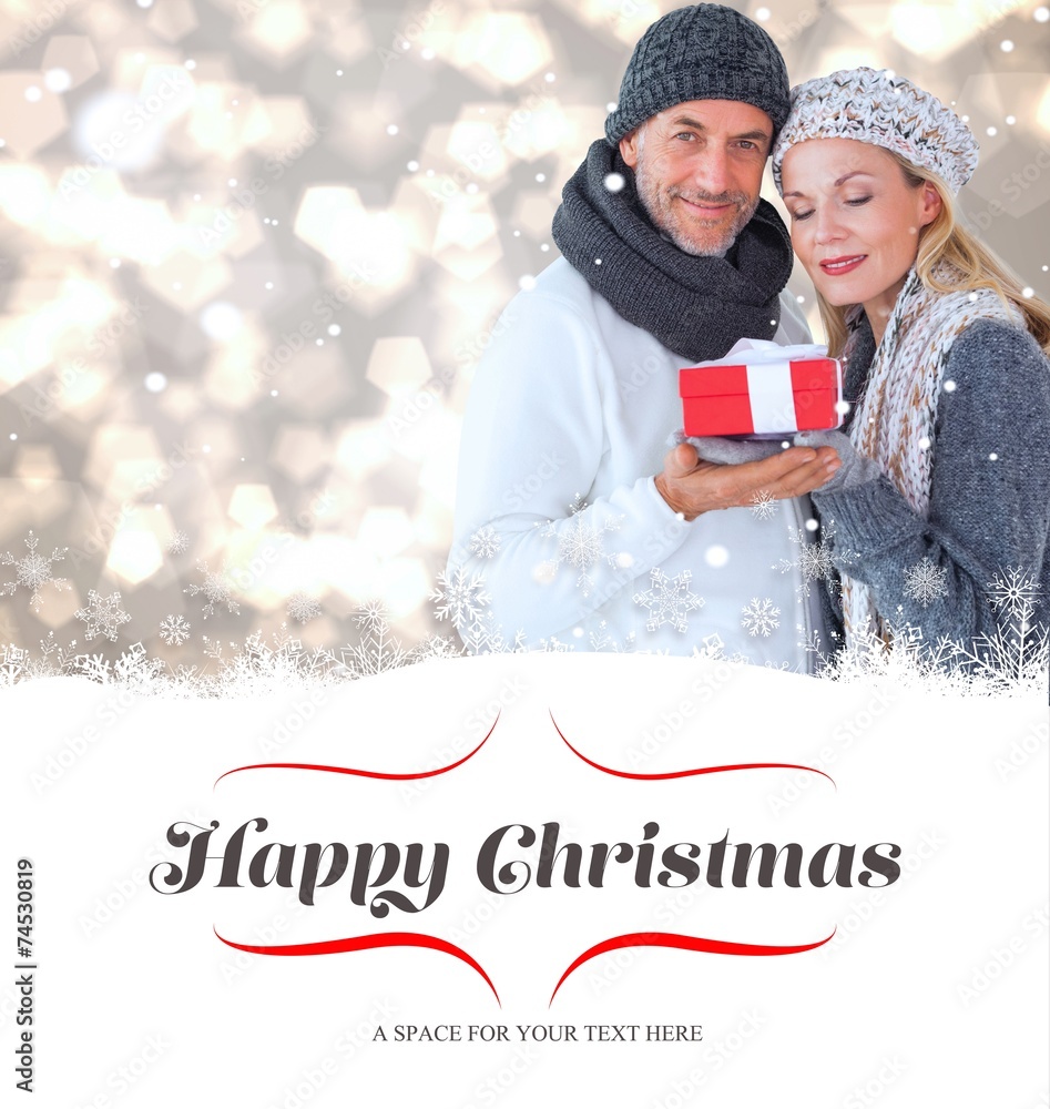 Composite image of happy winter couple with gift Composite image of happy winter couple with gift