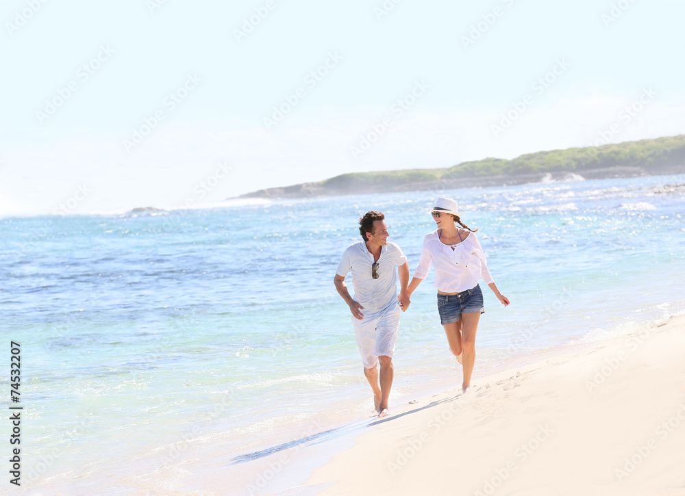 Couple running on a Caribbean beach