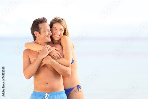Loving couple in swimsuit embracing at the beach