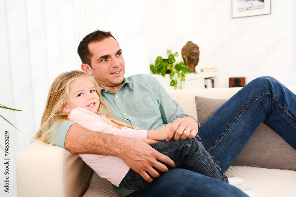 happy handsome young daddy and young daugther on sofa at home happy handsome young daddy and young daugther on sofa at home