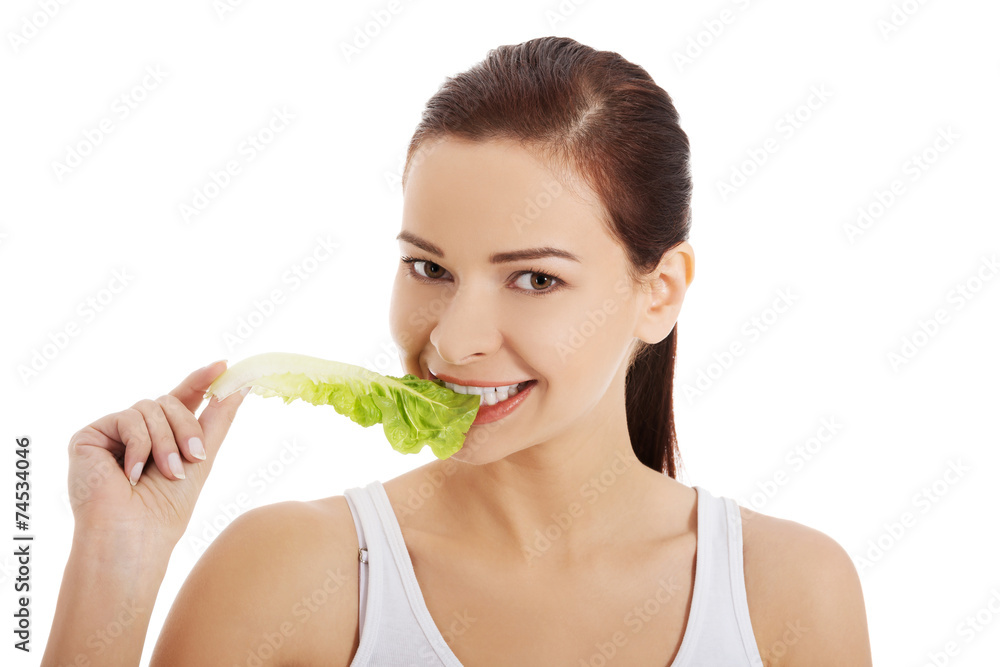 Portrait of a woman eating lettuce leaf Portrait of a woman eating lettuce leaf
