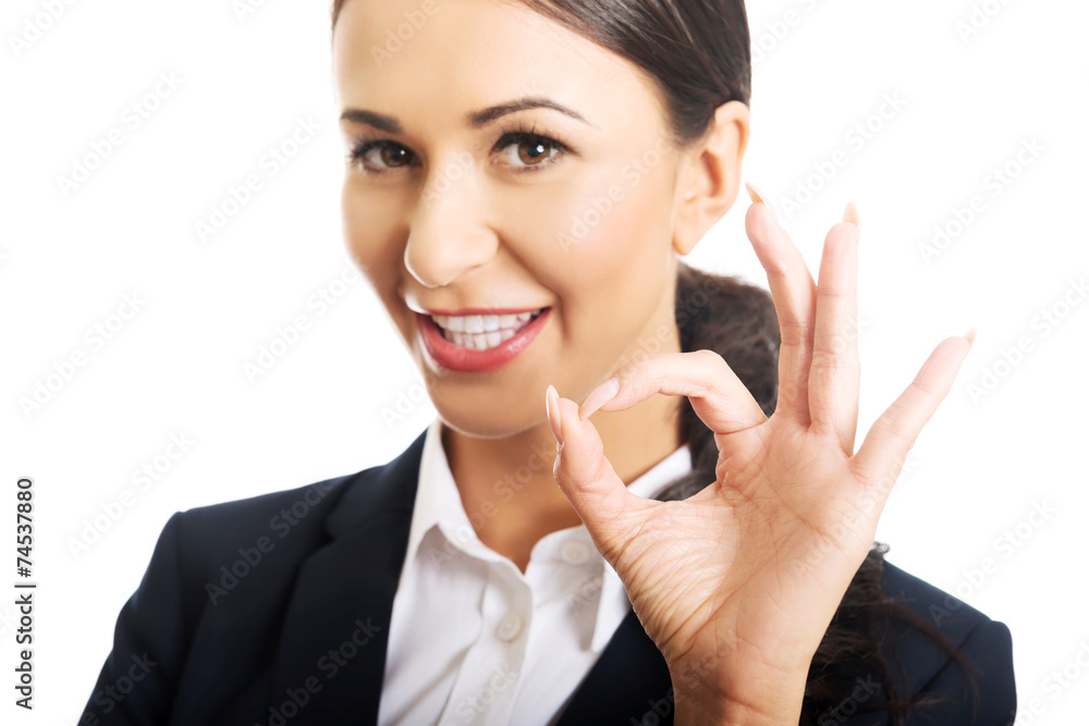 Businesswoman showing ok sign, looking at the camera Businesswoman showing ok sign, looking at the camera