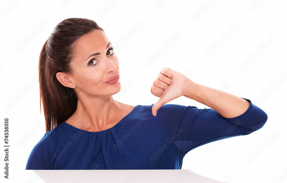 Attractive female in blue shirt with thumb down Attractive female in blue shirt with thumb down