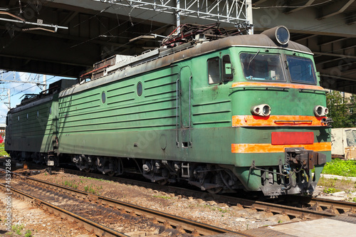 Green modern Russian locomotive with red stripes on cabin