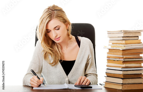 Woman preparing to exam, counting on calculator