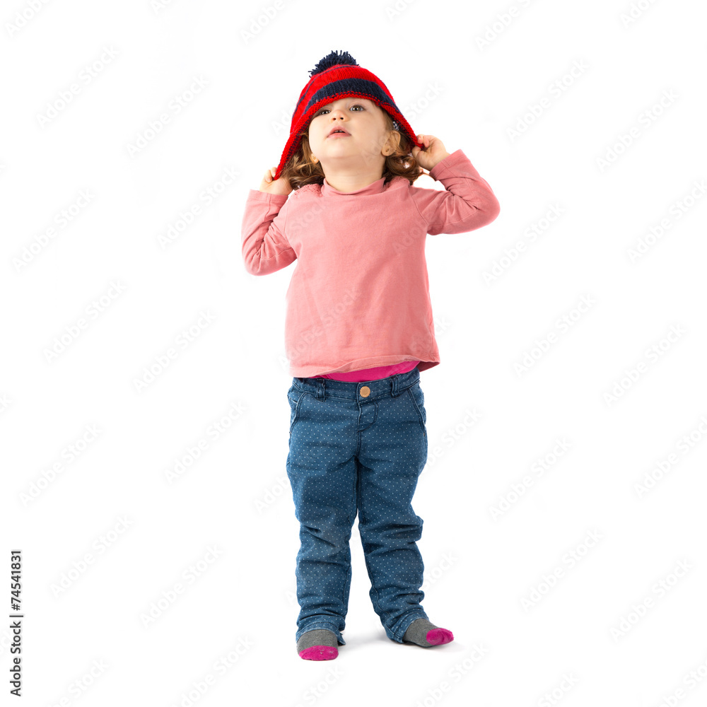 Little girl puttining on a Christmas hat over white background Little girl puttining on a Christmas hat over white background