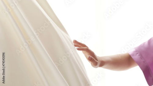 Bride touching wedding dress photo