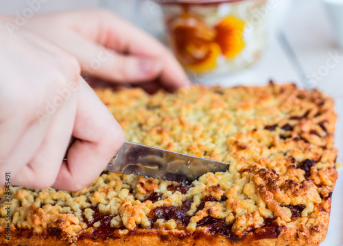 cut sweet tart pastry with apple jam, hands