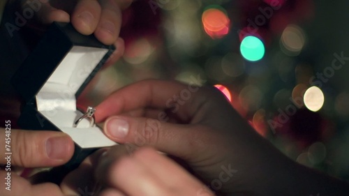 Engagement Ring Proposal Close Up. Christmas Tree Background 