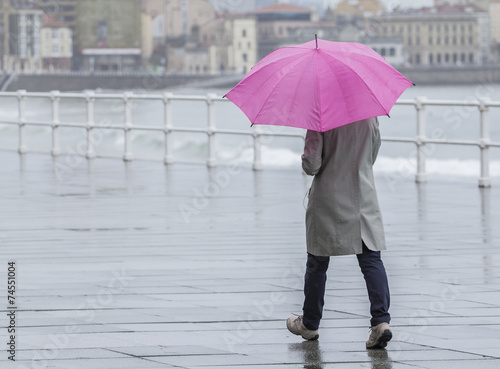 Mujer con paraguas paseando por la ciudad