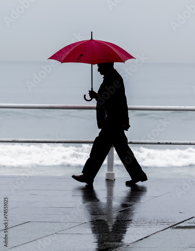 Hombre con paraguas paseando por la ciudad