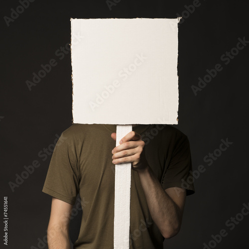 Obraz na płótnie Faceless person holding a blank sign