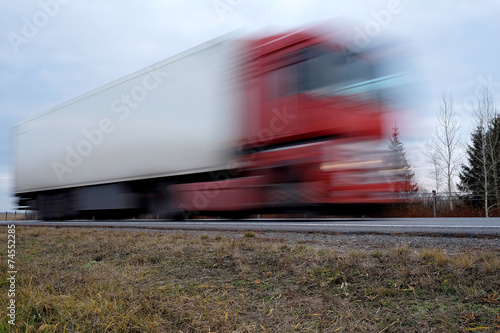 Truck on a hughway. Truck is blurred because of movement