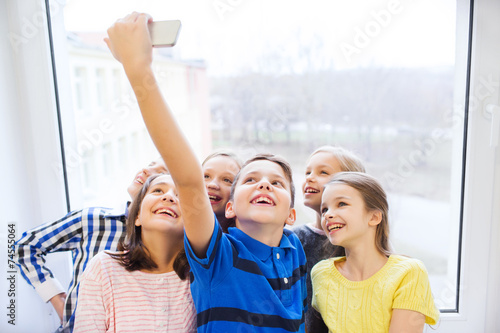 group of school kids taking selfie with smartphone