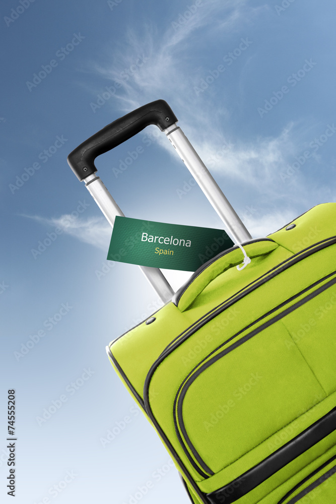 Barcelona, Spain. Green suitcase with label - obrazy, fototapety, plakaty 