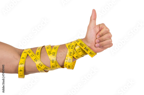man's arm wrapped in measuring tape holding thumb up