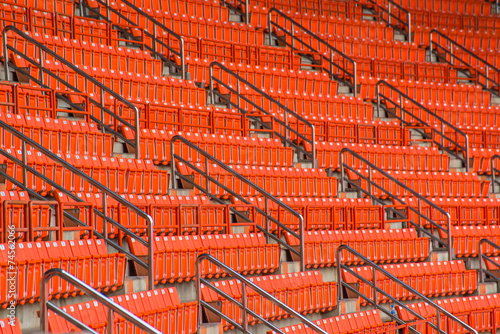 red seats on stadium steps bleacher with spot light pole
