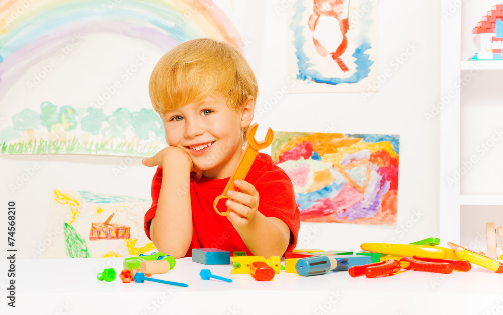 Handsome blond boy with wrench in kindergaten Handsome blond boy with wrench in kindergaten