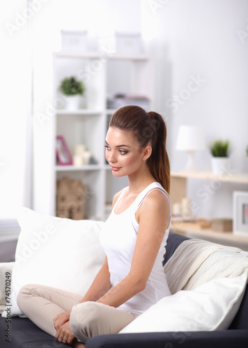 Woman sitting on the couch in  living room and smiling