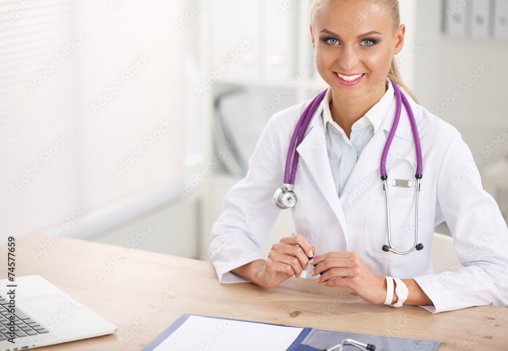 Beautiful young smiling female doctor sitting at the desk and Beautiful young smiling female doctor sitting at the desk and