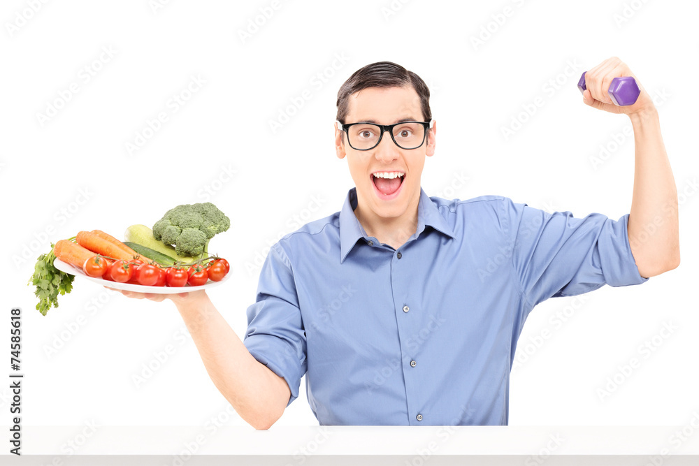 Man holding plate with vegetables and a dumbbell