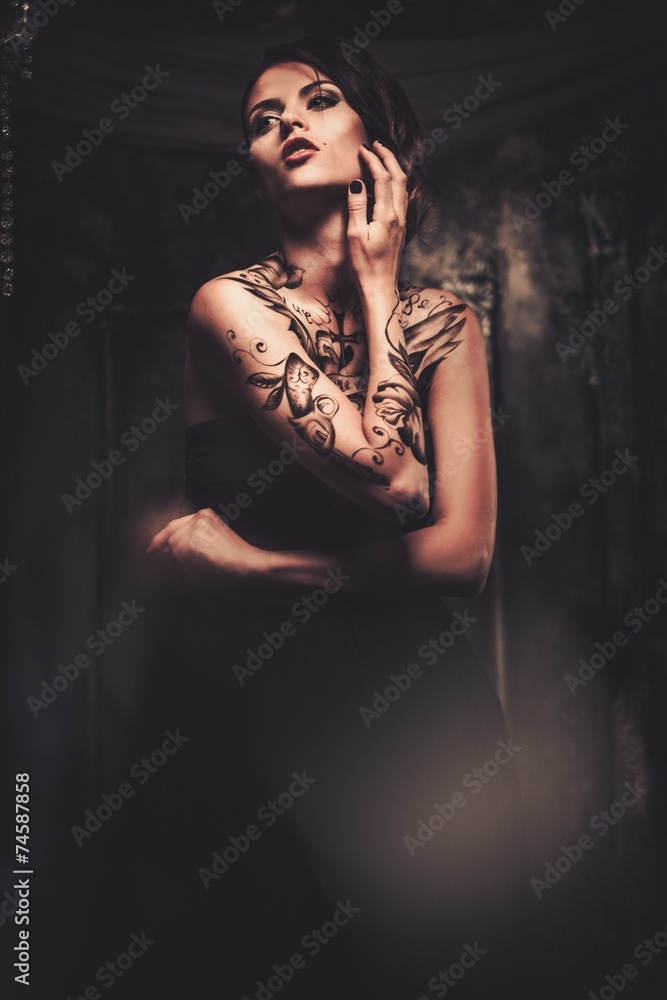 Tattooed beautiful woman in old spooky interior