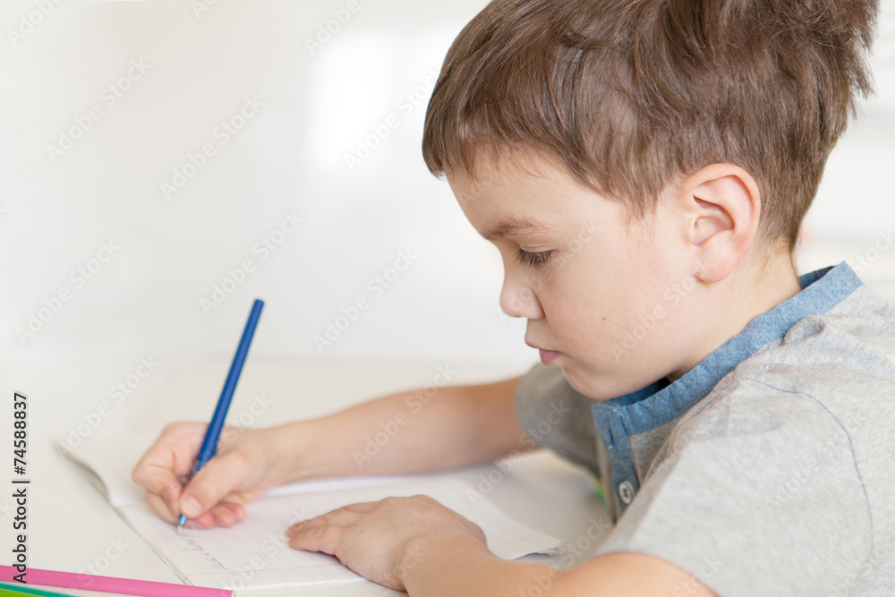 Serious pensive pupil sits at desk Serious pensive pupil sits at desk