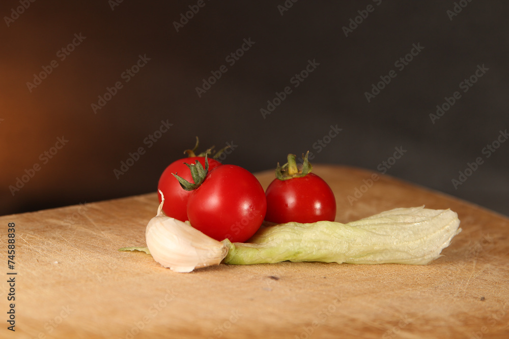 Tomatoes Garlic and Lettuce on Wood surface. Tomatoes Garlic and Lettuce on Wood surface.
