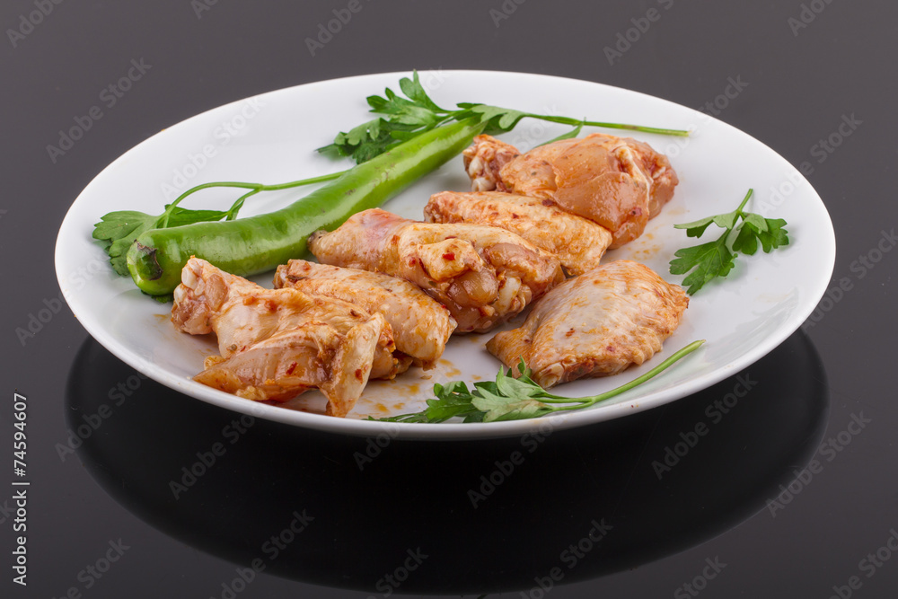 raw chicken legs and chicken wings on a plate raw chicken legs and chicken wings on a plate