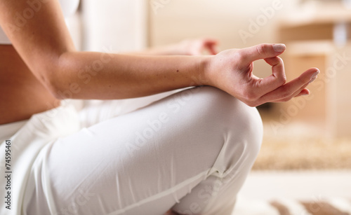 Young woman meditate in her living room.