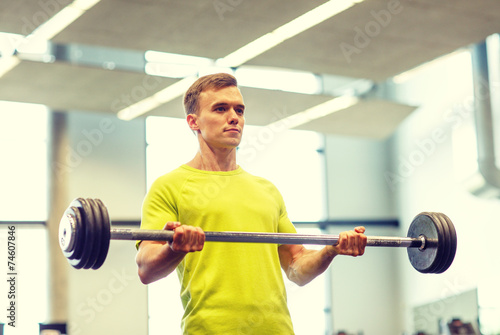 man doing exercise with barbell in gym