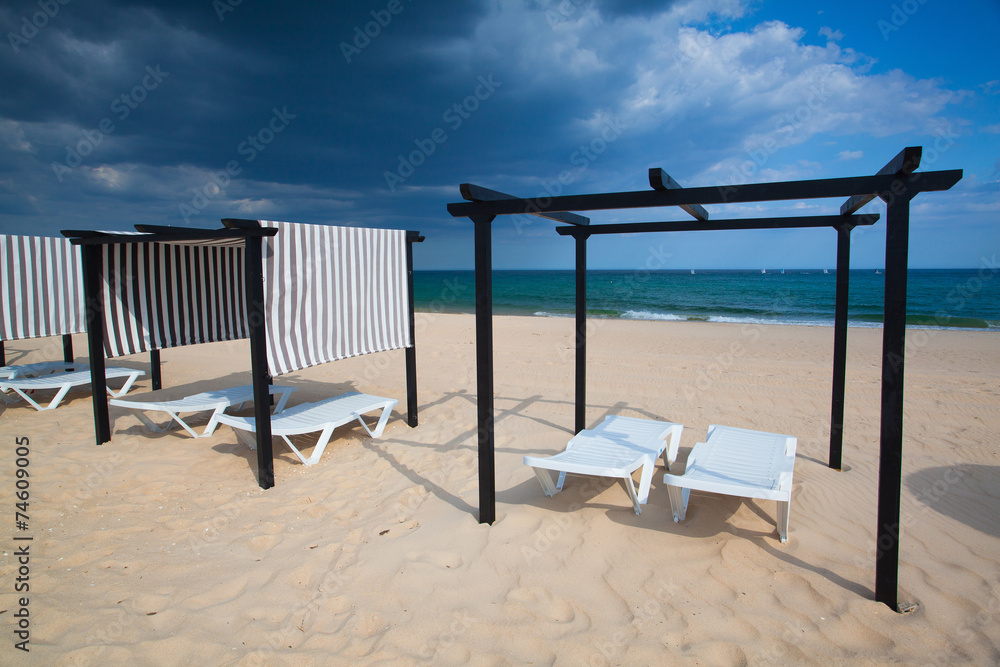 Different parasols and sun loungers on the empty beach on Tavira Different parasols and sun loungers on the empty beach on Tavira