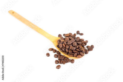 Lots of coffee beans on wooden spoon. White background. Isolated